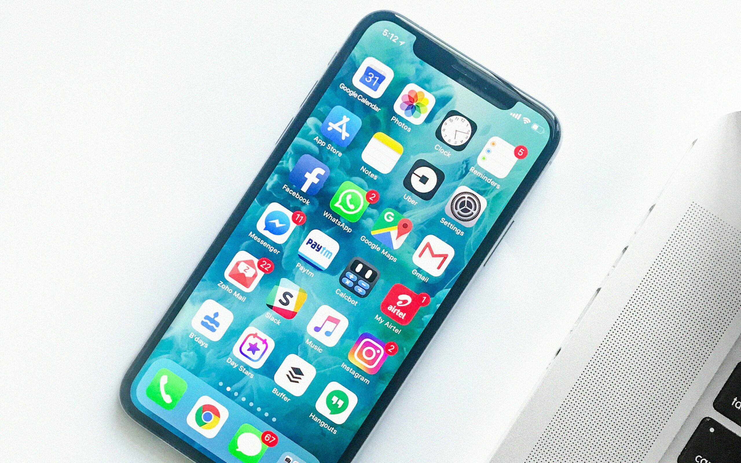 Photo of an iPhone with its home screen open, displaying various app icons.