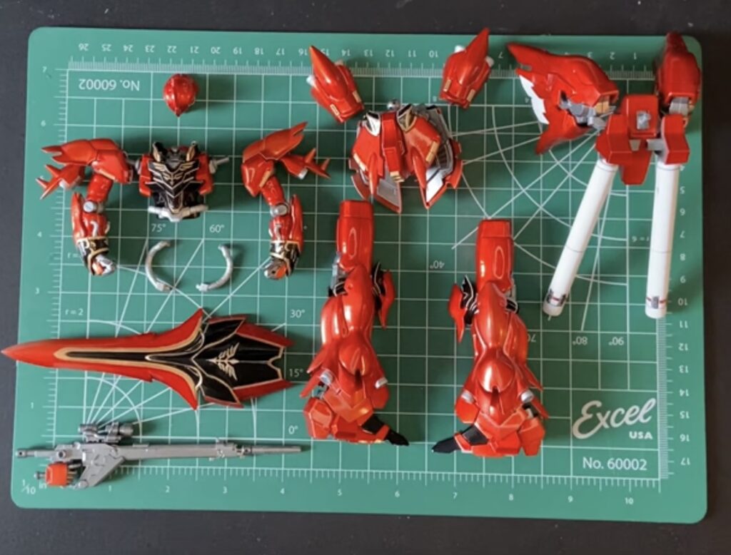 Image of partially assembled gundam parts organized on a green hobby mat