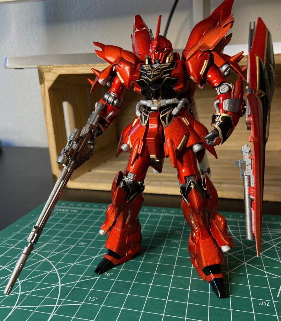 Image of a finished red painted gundam model standing on a hobby mat